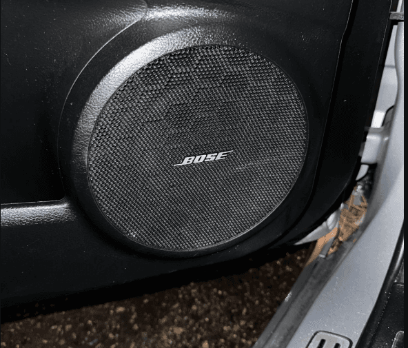 The repaired Bose speaker back in place in the car door, behind its black grille.